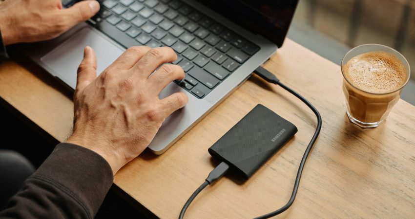 A man sitting at a table using a laptop computer