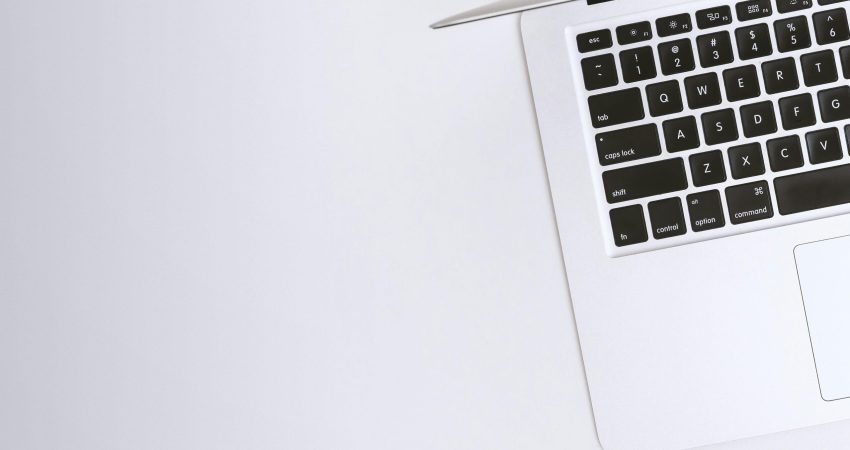 Free Aerial view of a sleek laptop keyboard on a clean, white surface, ideal for tech backgrounds. Stock Photo