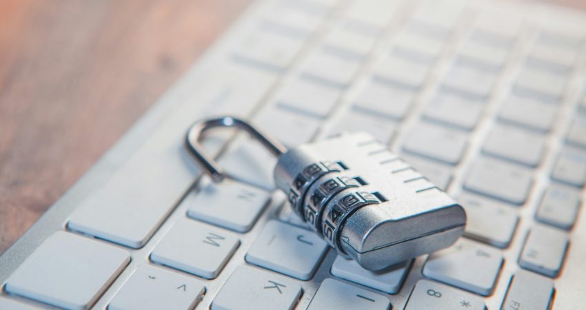 A combination lock rests on a computer keyboard.